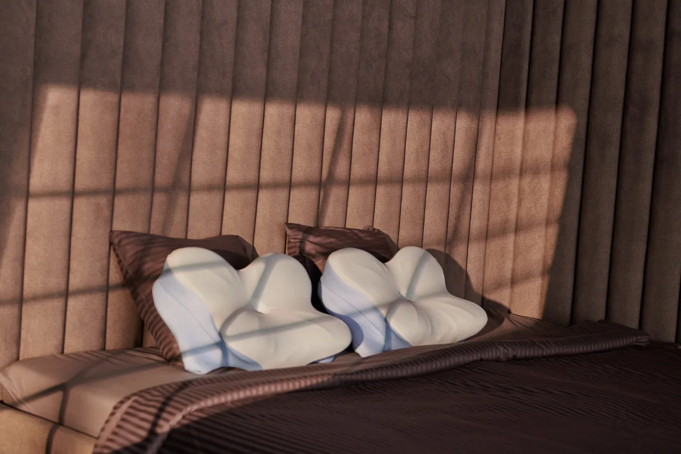 Two white-and-blue butterfly-shaped pillows arranged on a bed in a softly lit bedroom